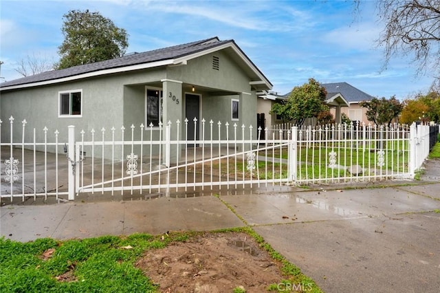 ranch-style home with a fenced front yard and stucco siding