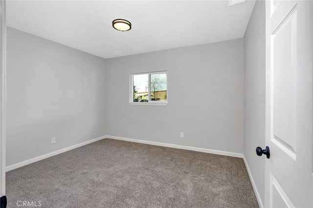 carpeted empty room featuring baseboards