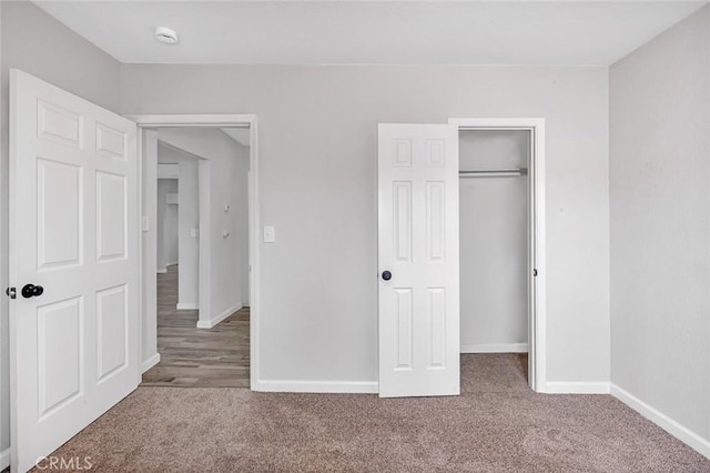 unfurnished bedroom featuring baseboards, a closet, and carpet