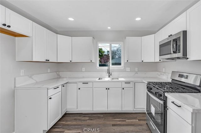 kitchen featuring white cabinets, dark wood-style floors, a sink, and appliances with stainless steel finishes