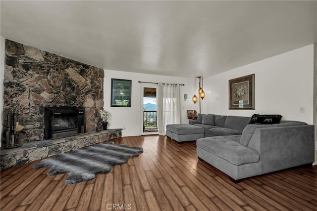 living area featuring a stone fireplace and wood finished floors