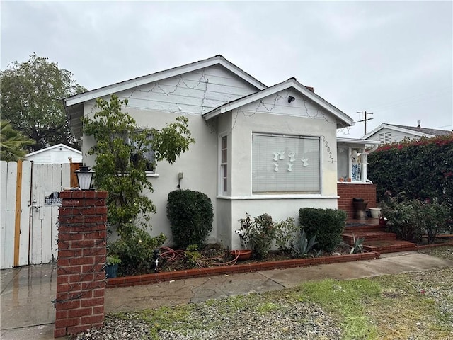 bungalow-style home featuring stucco siding