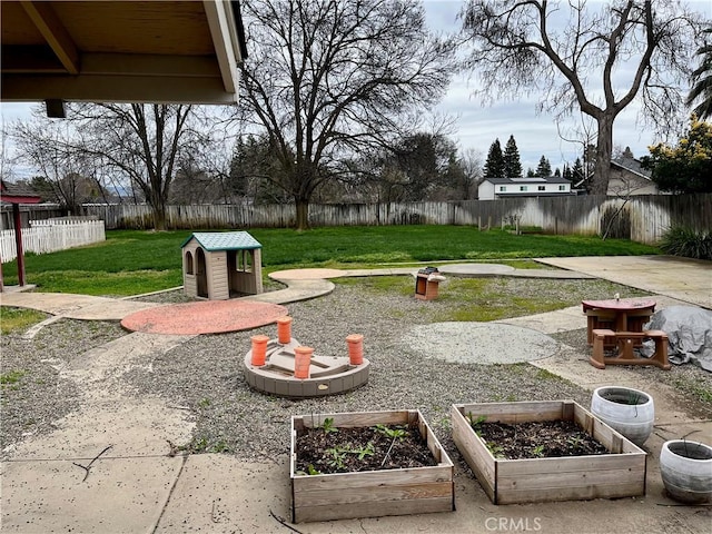 view of yard with a garden, a fenced backyard, and a patio area