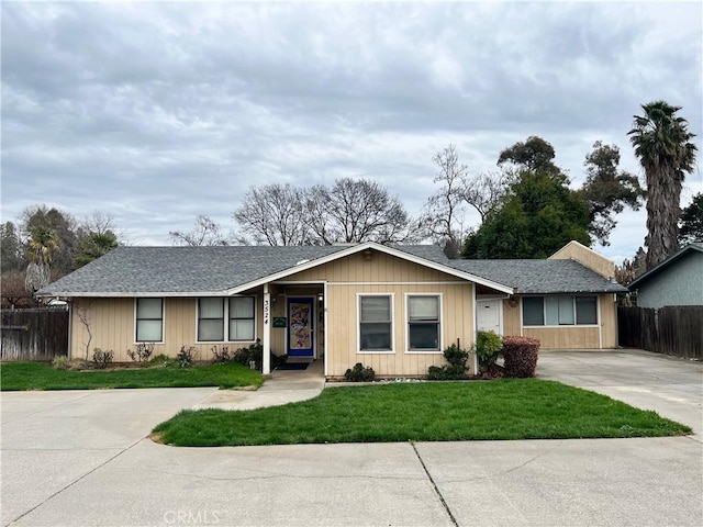 ranch-style home featuring concrete driveway, a front lawn, and fence