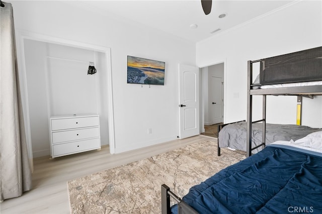 bedroom with visible vents, ornamental molding, baseboards, and wood finished floors