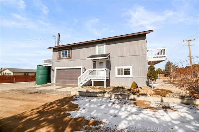 view of front of home featuring a garage, driveway, and fence