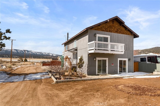 back of house with a balcony and fence