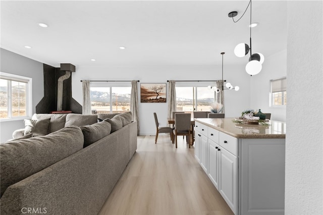 living area featuring recessed lighting, plenty of natural light, and light wood-style floors