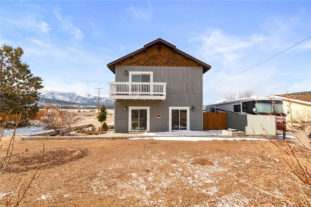 back of house with a balcony, fence, and a mountain view