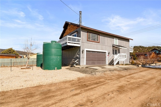 view of home's exterior featuring driveway, an attached garage, and fence