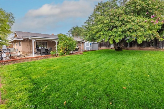 view of yard featuring a shed, a patio, an outdoor structure, and a fenced backyard