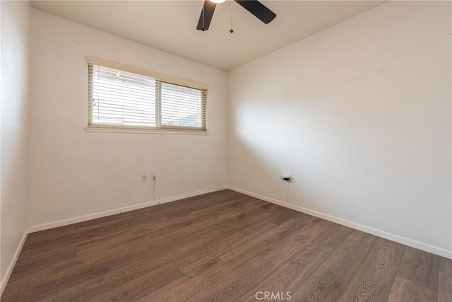 unfurnished room with dark wood-style floors, baseboards, and ceiling fan