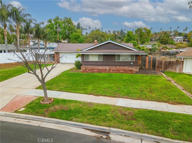 view of front of house featuring driveway, a front yard, and fence