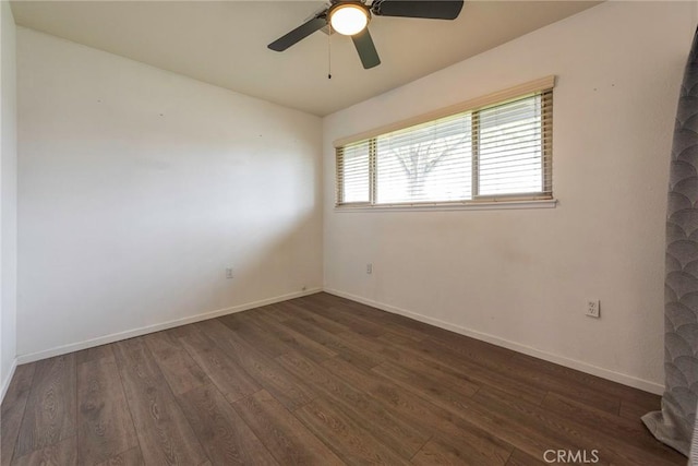 spare room with dark wood-style floors, baseboards, and ceiling fan