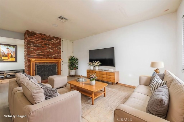 living area with light tile patterned flooring, visible vents, and a brick fireplace