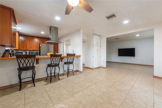 kitchen with ventilation hood, visible vents, recessed lighting, stainless steel appliances, and brown cabinets