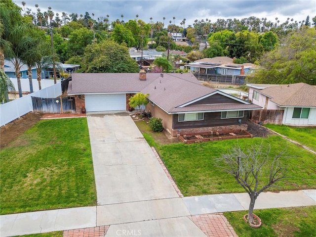 view of front of home featuring a front yard, fence, an attached garage, a shingled roof, and concrete driveway