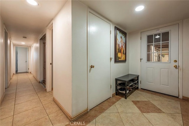 corridor with light tile patterned floors, baseboards, and recessed lighting