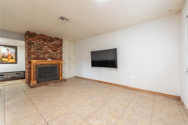 unfurnished living room with light tile patterned floors, visible vents, a brick fireplace, and baseboards