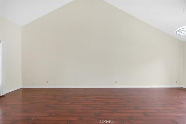 unfurnished room with lofted ceiling, wood finished floors, and baseboards