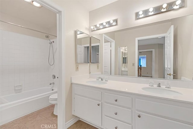 bathroom with tile patterned floors, double vanity, toilet, and a sink