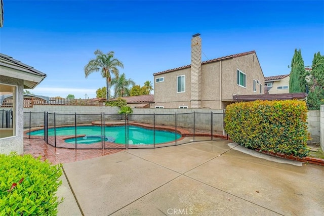 view of pool featuring a patio area, a pool with connected hot tub, and a fenced backyard