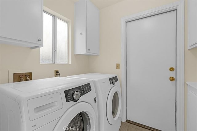 laundry area featuring light tile patterned floors, cabinet space, and independent washer and dryer