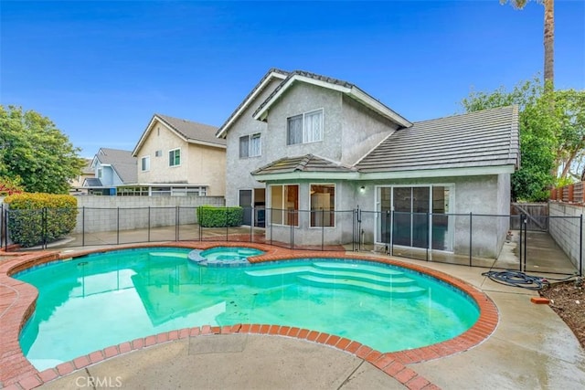 view of pool with a patio, a fenced backyard, and a pool with connected hot tub