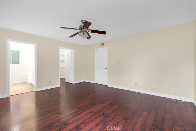 empty room featuring visible vents, wood finished floors, baseboards, and ceiling fan