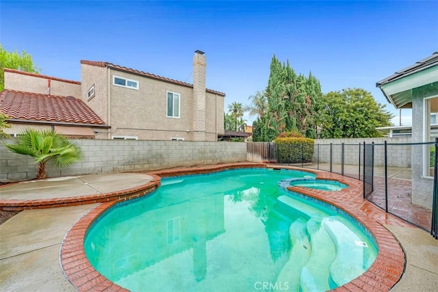 view of pool featuring a patio area, a fenced backyard, and a pool with connected hot tub