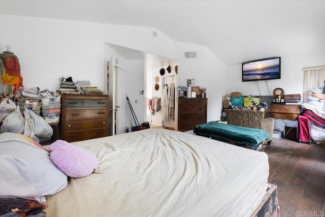 bedroom with vaulted ceiling, wood finished floors, and visible vents