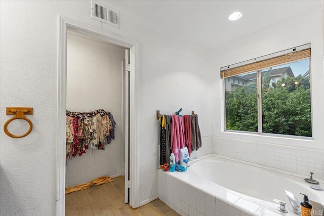 full bath featuring a bath, visible vents, and wood finished floors