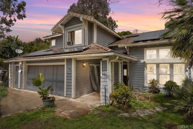 traditional home with roof mounted solar panels and a garage