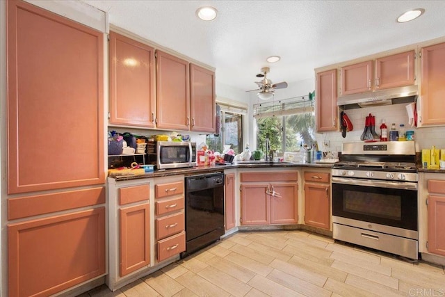 kitchen featuring a sink, dark countertops, under cabinet range hood, and stainless steel appliances