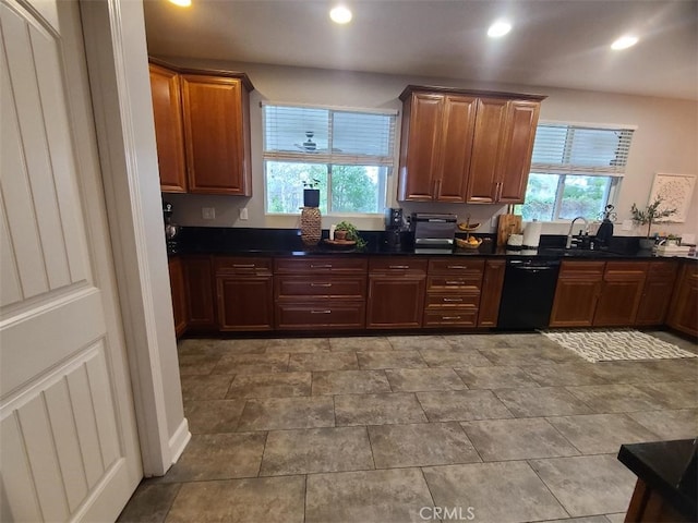 kitchen featuring dark countertops, recessed lighting, dishwasher, and a sink