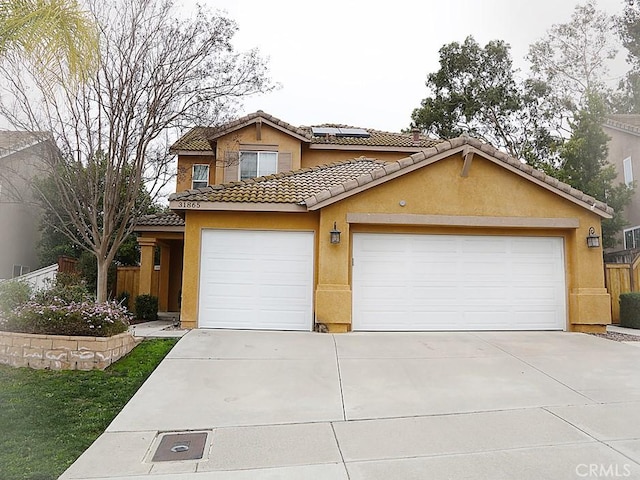 view of front facade with stucco siding, an attached garage, a tile roof, and solar panels