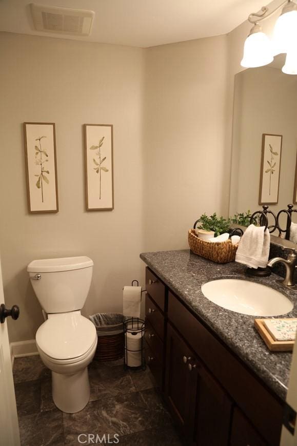 bathroom featuring visible vents, toilet, and vanity