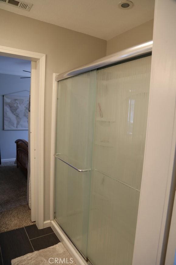 bathroom featuring tile patterned floors, visible vents, and a shower stall