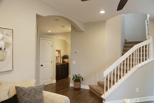 staircase with wood finished floors, a ceiling fan, baseboards, recessed lighting, and arched walkways