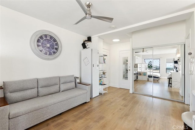 living room with light wood-style floors and a ceiling fan