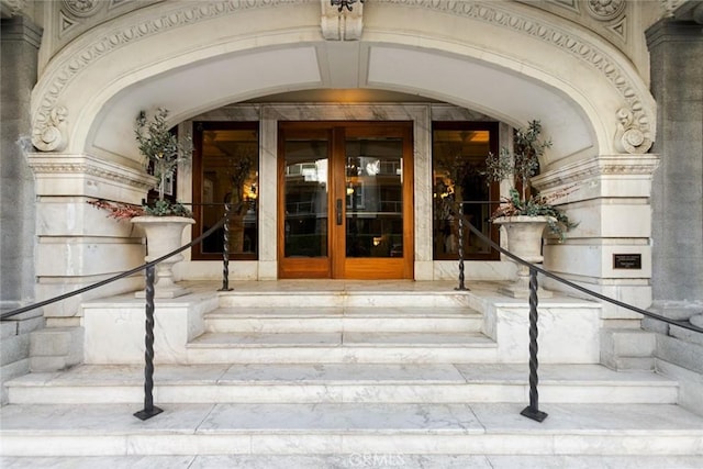 view of exterior entry featuring french doors and stone siding