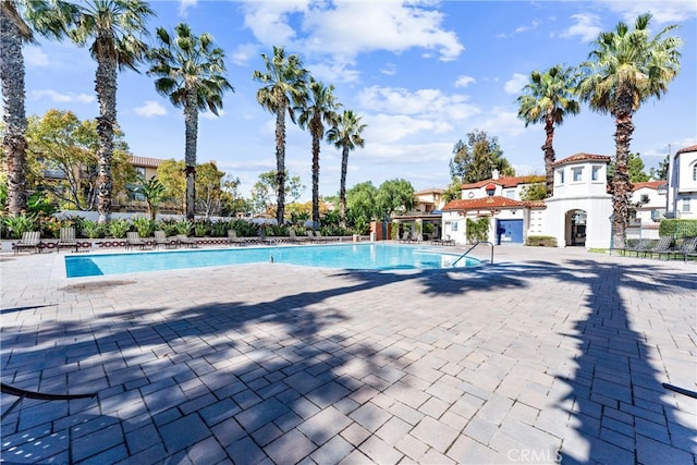 community pool with a patio and fence