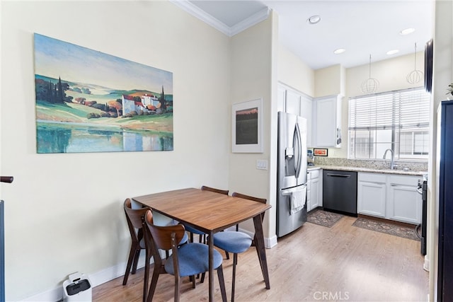 kitchen with crown molding, dishwasher, light wood-type flooring, white cabinets, and stainless steel fridge