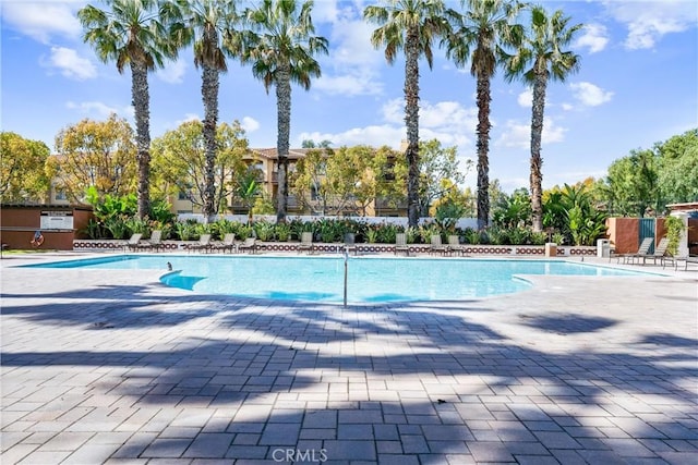 pool with a patio and fence