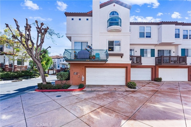 view of front of house featuring stucco siding, driveway, an attached garage, and a tiled roof