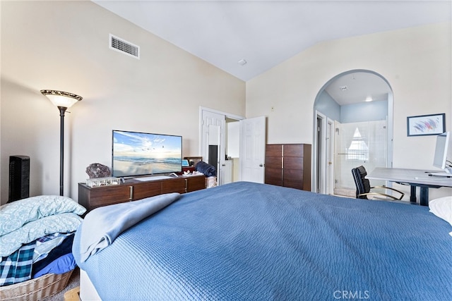 bedroom featuring visible vents, arched walkways, ensuite bathroom, and vaulted ceiling