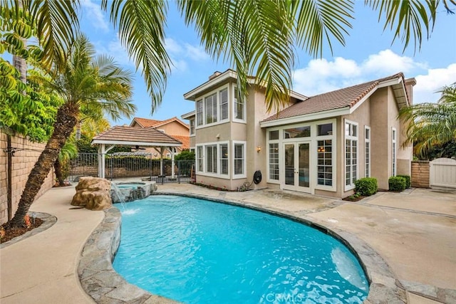 view of swimming pool featuring a fenced backyard, a gazebo, french doors, a fenced in pool, and an in ground hot tub