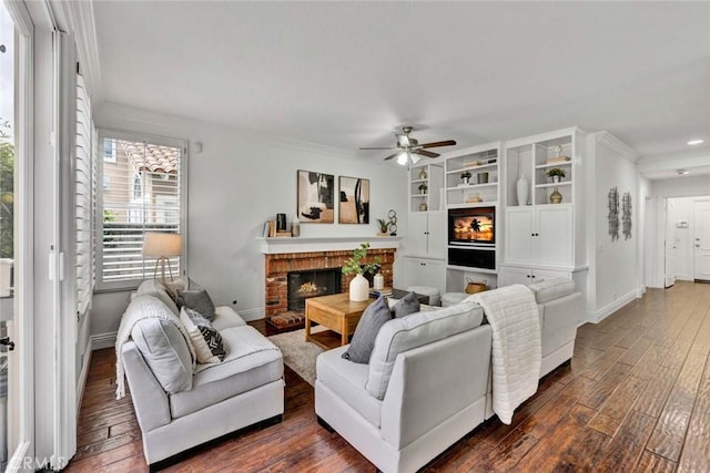 living area with dark wood finished floors, a fireplace, baseboards, and ceiling fan