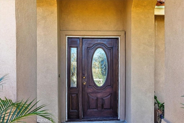 view of exterior entry with stucco siding