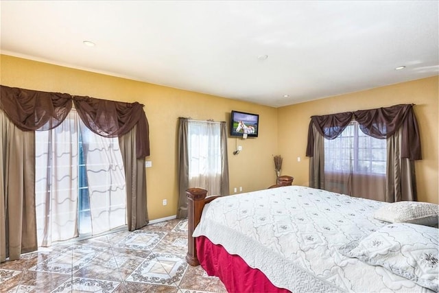 bedroom featuring baseboards, multiple windows, and access to outside